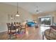 Open-concept living room with dining area, vaulted ceilings, and sliding door access to the balcony at 7201 29Th Avenue W Dr # 309, Bradenton, FL 34209