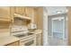 Open kitchen layout with light wood cabinets and white appliances at 750 N Tamiami Trl # 504, Sarasota, FL 34236