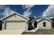 New construction home with a two-car garage and neutral exterior at 890 Indus Rd, Venice, FL 34293