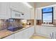 Kitchen boasts granite countertops, white cabinets, and ocean views at 1241 Gulf Of Mexico Dr # 708, Longboat Key, FL 34228