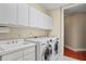 Bright laundry room with washer, dryer, and extra storage at 1241 Gulf Of Mexico Dr # 708, Longboat Key, FL 34228