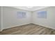 Simple bedroom with wood-look floors and two windows at 3442 Fairview Dr, Sarasota, FL 34239