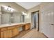 Bright bathroom featuring double sinks with wood cabinets and a large mirror at 10444 48Th E Ct, Parrish, FL 34219