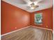 Cozy bedroom with wood floors, a ceiling fan, and natural light from a large window at 10444 48Th E Ct, Parrish, FL 34219