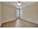 Empty bedroom with wood-look floors, neutral walls, ceiling fan, and a window with blinds at 10444 48Th E Ct, Parrish, FL 34219