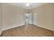 Empty bedroom with wood-look floors, neutral walls, ceiling fan, and closet with mirrored doors at 10444 48Th E Ct, Parrish, FL 34219