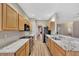 Galley kitchen with stainless steel appliances, light wood cabinets, and granite countertops at 10444 48Th E Ct, Parrish, FL 34219