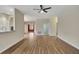 Spacious living room with wood-look floors, neutral walls, ceiling fan, and open access to other rooms at 10444 48Th E Ct, Parrish, FL 34219