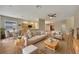 Open-concept living room with wood floors, neutral walls, ceiling fan, and views of the kitchen and dining area at 10444 48Th E Ct, Parrish, FL 34219