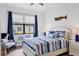 Guest bedroom with white bed frame and blue striped bedding at 15967 Clear Skies Pl, Lakewood Ranch, FL 34211