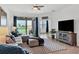 Relaxing living room with sectional sofa, large TV, and access to a back patio at 15967 Clear Skies Pl, Lakewood Ranch, FL 34211
