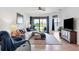 Spacious living room with sectional sofa, ottoman, and a view of a tranquil lake at 15967 Clear Skies Pl, Lakewood Ranch, FL 34211