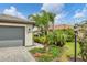 Gray three-car garage with a landscaped walkway, and a view of neighboring houses at 15967 Clear Skies Pl, Lakewood Ranch, FL 34211