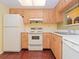 Kitchen features wood cabinets, white appliances, and wood-look floors at 2465 Northside Dr # 906, Clearwater, FL 33761