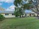 Backyard view of a light yellow house with a large tree and grassy lawn at 2465 Northside Dr # 906, Clearwater, FL 33761