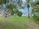 Backyard of a light teal house with palm trees and lush grass at 2465 Northside Dr # 906, Clearwater, FL 33761