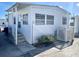 White single-wide mobile home with covered porch and steps at 3710 Gulf Of Mexico Dr # F1, Longboat Key, FL 34228