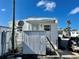 Rear view of a mobile home with a shed and satellite dish at 3710 Gulf Of Mexico Dr # F1, Longboat Key, FL 34228
