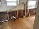 View of the kitchen's needed renovation, with exposed wall studs, plumbing, plywood flooring, and updated electrical at 3710 Gulf Of Mexico Dr # F1, Longboat Key, FL 34228