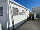 Side view of a white mobile home, showing windows and landscaping at 3710 Gulf Of Mexico Dr # F1, Longboat Key, FL 34228