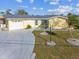 Light yellow single Gathering home with a driveway and mature landscaping at 5112 Beacon Rd, Palmetto, FL 34221