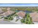 An aerial view of a neighborhood with a lake, lush landscaping, and well-maintained houses with tile roofs at 7011 Woodmore Ter, Lakewood Ranch, FL 34202