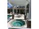 Relaxing outdoor hot tub under a pergola with stone pillars near a pool and lounge area at 7011 Woodmore Ter, Lakewood Ranch, FL 34202