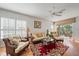 Cozy living room with plush seating, wood floors, and natural light from the window shutters at 7011 Woodmore Ter, Lakewood Ranch, FL 34202