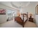 Spacious main bedroom featuring a tray ceiling, ceiling fan and large windows at 7011 Woodmore Ter, Lakewood Ranch, FL 34202
