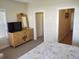 Bedroom with dresser, TV, and access to bathroom and hallway at 11776 Angler'S Club Dr, Placida, FL 33946