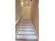 Modern staircase with white risers and wood treads at 11776 Angler'S Club Dr, Placida, FL 33946