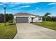 Modern house with a gray garage door and a well-maintained lawn at 12928 24Th E Ct, Parrish, FL 34219