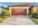 House exterior with a brown garage door and landscaped yard at 13816 Miranese St, Venice, FL 34293