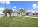 Charming single-story home with a spacious front yard, long driveway, and white picket fence at 15 Tulane Rd, Venice, FL 34293