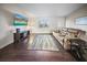 Living room with dark wood floors, sectional sofa, and large TV at 15 Tulane Rd, Venice, FL 34293