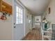 Long hallway with light wood flooring and access to other rooms at 2609 Riverbluff Pkwy # 146, Sarasota, FL 34231