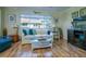 Living room with comfy seating, wood floors, and large window at 2609 Riverbluff Pkwy # 146, Sarasota, FL 34231