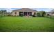 Spacious backyard with lush green grass and a screened lanai for outdoor relaxation at 409 147Th Ne Ct, Bradenton, FL 34212