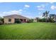 Home exterior showcasing expansive backyard, screened lanai, and lush landscaping at 409 147Th Ne Ct, Bradenton, FL 34212