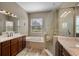 Bright bathroom featuring a soaking tub, glass shower, dual sinks, and modern fixtures at 409 147Th Ne Ct, Bradenton, FL 34212