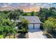 Aerial view of a home with a two-car garage and driveway surrounded by lush tropical landscaping and mature trees at 4589 Trails Dr, Sarasota, FL 34232