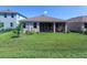 Exterior view of home showcasing screened lanai and large backyard with green grass at 5719 Woodland Sage Dr, Sarasota, FL 34238