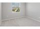 Neutral bedroom features light gray carpet, light walls, and a bright window at 5719 Woodland Sage Dr, Sarasota, FL 34238