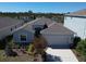 Charming home featuring a two-car garage, front yard landscaping, and a neutral color scheme at 5719 Woodland Sage Dr, Sarasota, FL 34238