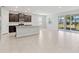 Open kitchen with island, granite countertops, dark brown cabinets, and tile floors at 5719 Woodland Sage Dr, Sarasota, FL 34238