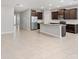 Open concept kitchen features dark cabinetry, a large island, stainless steel appliances, and tile flooring at 5719 Woodland Sage Dr, Sarasota, FL 34238