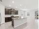 Bright kitchen boasts a granite island, sleek appliances, dark cabinetry and white subway tile backsplash at 5719 Woodland Sage Dr, Sarasota, FL 34238