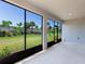 View from the screened lanai towards the yard featuring lush green landscaping and trees at 5719 Woodland Sage Dr, Sarasota, FL 34238