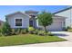 Single-story home with gray exterior, landscaping and two-car garage at 5719 Woodland Sage Dr, Sarasota, FL 34238
