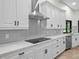 Modern kitchen with white cabinets, quartz countertops, and a stainless steel range hood at 6817 Riverview Blvd, Bradenton, FL 34209